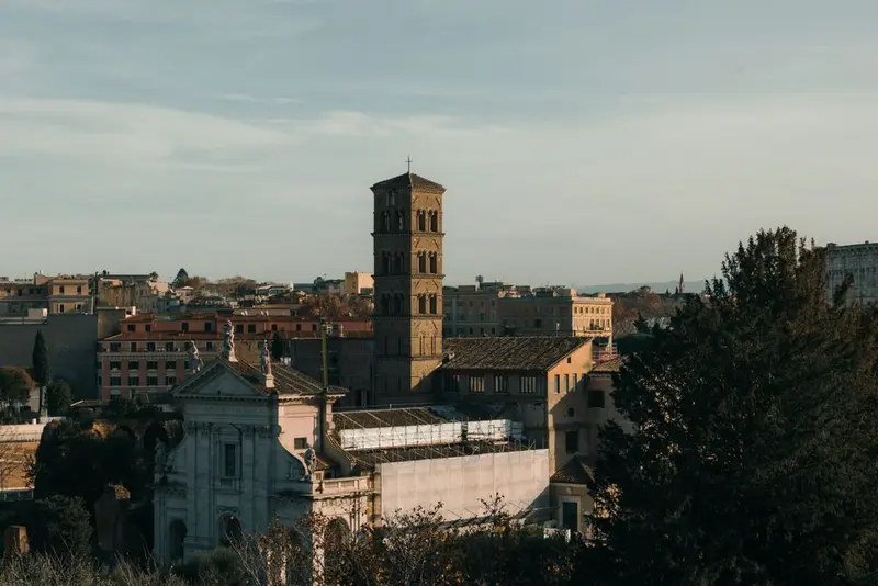 A stunning view of historic Roman architecture bathed in warm sunset light, showcasing iconic structures in Rome, Italy.