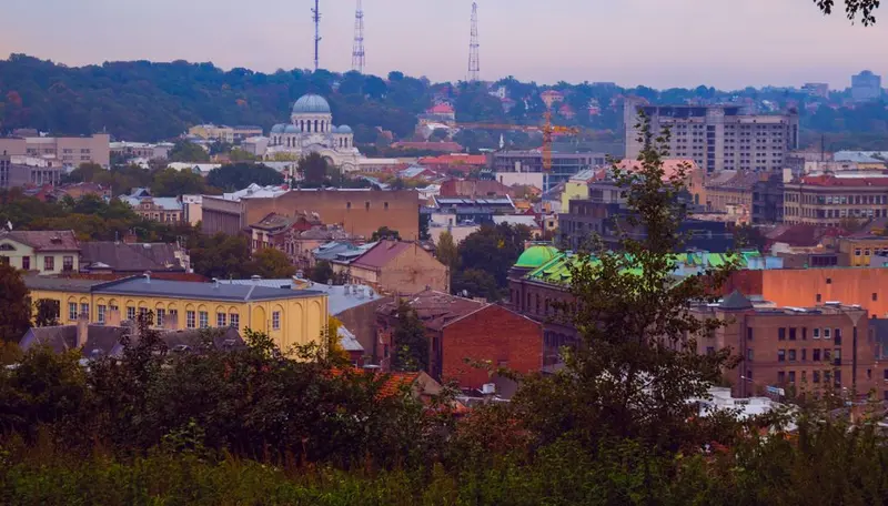 Aerial view of a historical European city with lush greenery and vibrant architecture.
