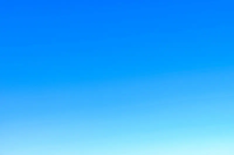 A serene view of a vibrant clear blue sky with a subtle gradient, perfect for backgrounds.