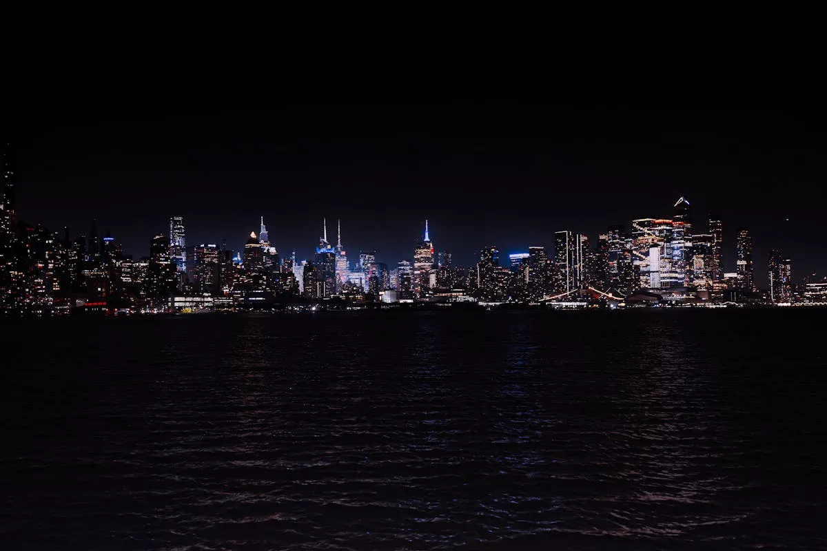 Breathtaking night view of the illuminated New York City skyline across the water.