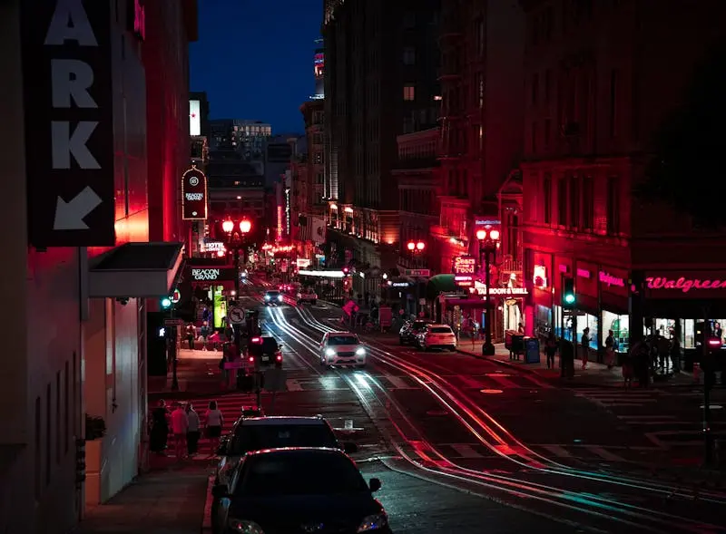Bustling nighttime street scene in San Francisco with neon lights and lively atmosphere.