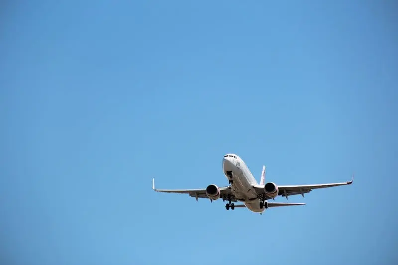 Virgin Australia aircraft captured mid-landing against a clear blue sky at Melbourne Airport.