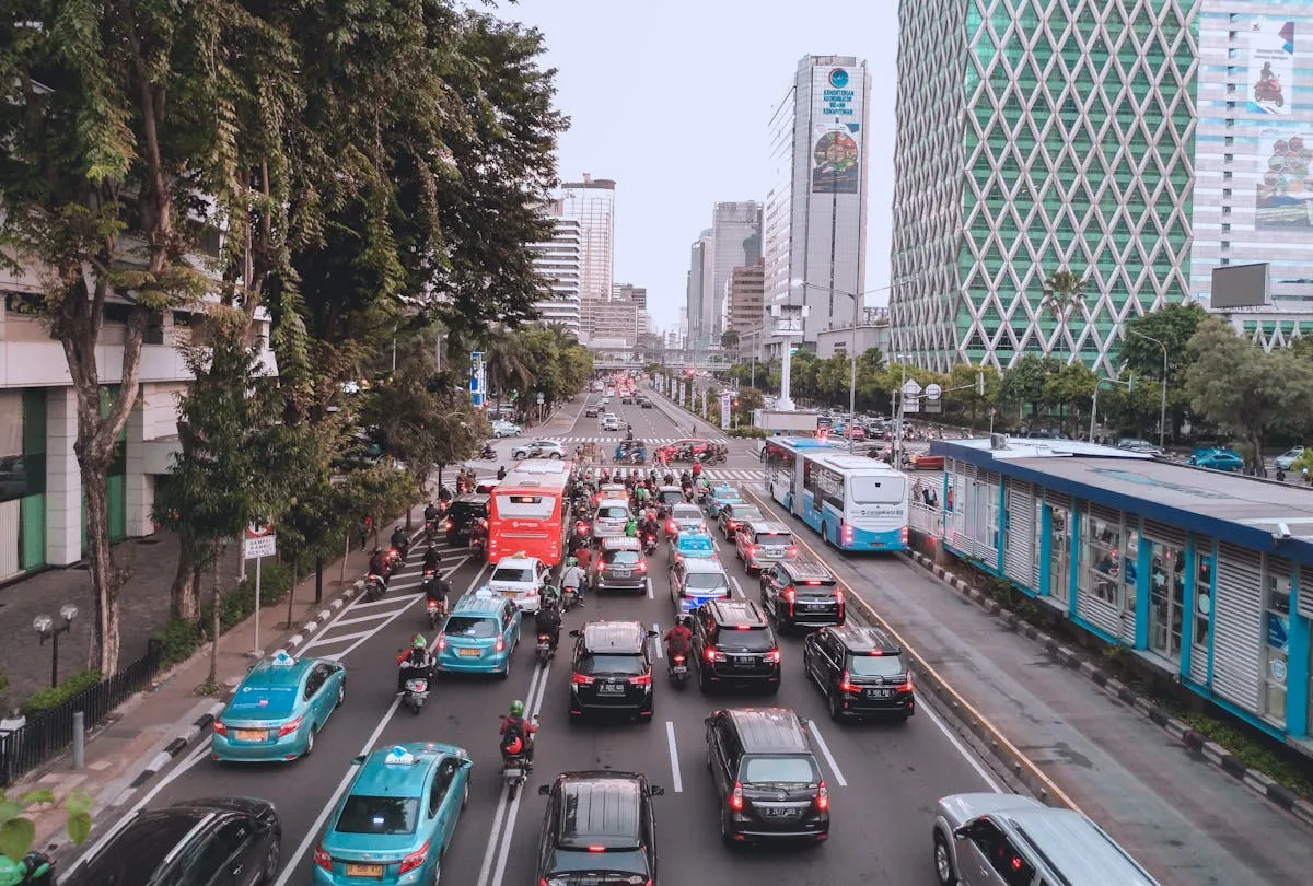 A bustling city street filled with cars and buses during the day.