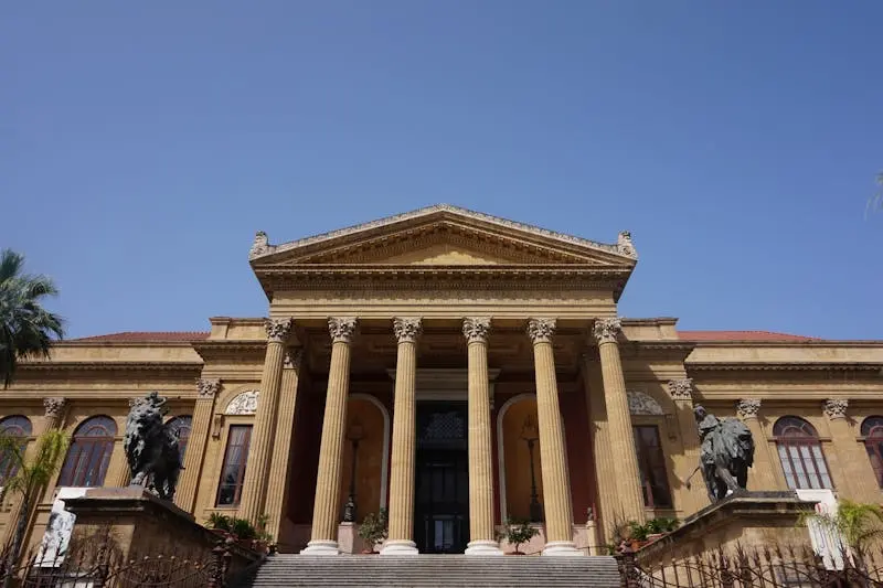 Stunning view of Teatro Massimo in Palermo showcasing neoclassical architecture under a clear blue sky.