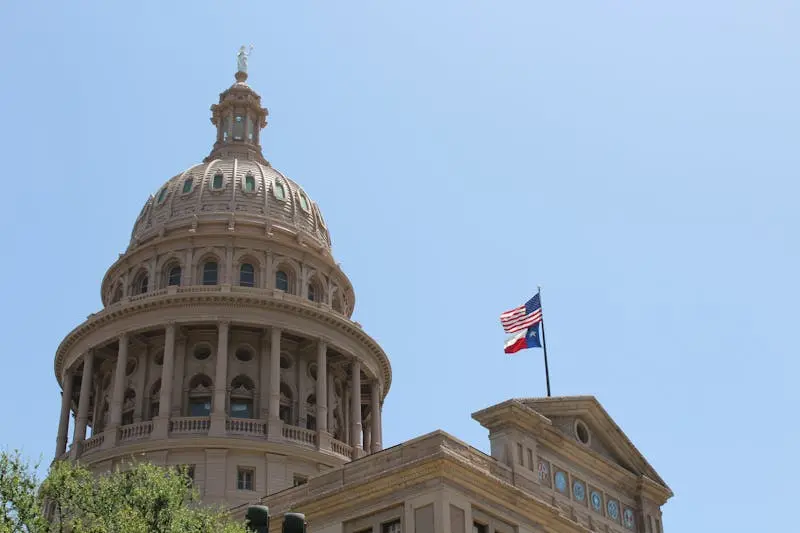Low angle view of the Texas State Capitol dome and flags in Austin, Texas.