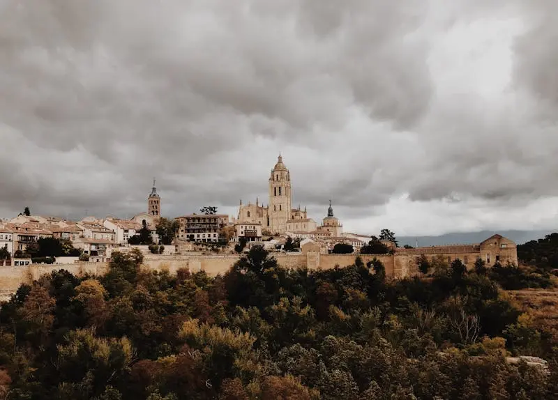 Stunning view of Segovia Cathedral with dramatic clouds and historic architecture in Spain.