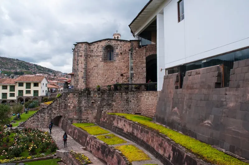View of the historic Coricancha temple in Cusco, featuring Inca stonework and gardens.