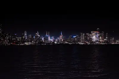 Breathtaking night view of the illuminated New York City skyline across the water.