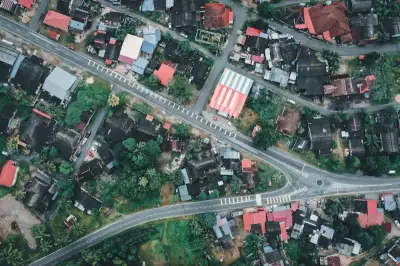 High-angle shot of residential architecture in Chukai, Terengganu, Malaysia, showcasing vibrant rooftops and lush greenery.