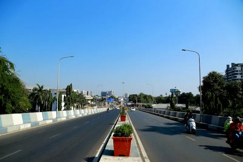 An urban highway in Surat, India, showcasing city infrastructure and traffic under a clear blue sky.