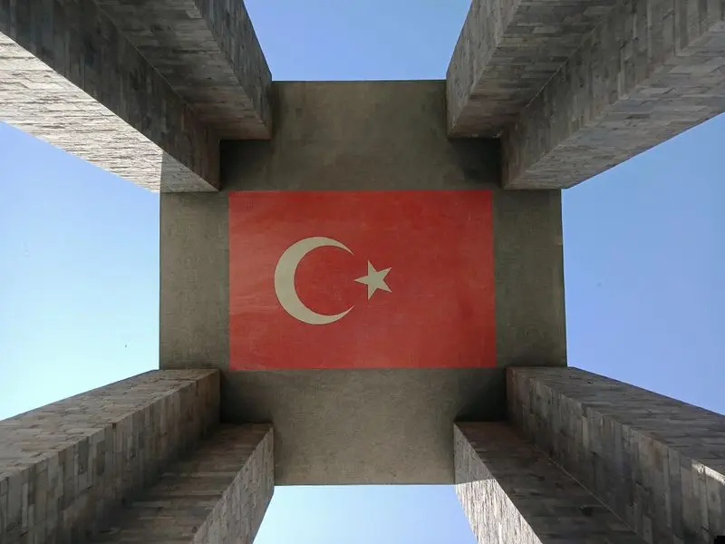Looking up at the iconic Çanakkale Martyrs' Memorial showcasing the Turkish flag.