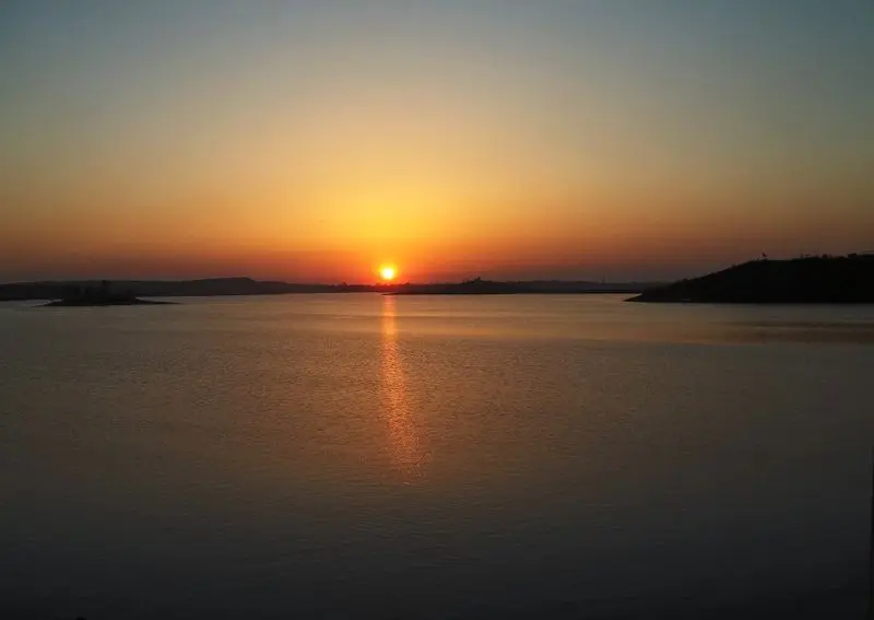 Tranquil sunset reflecting over Bhopal Lake in India, capturing nature's beauty.