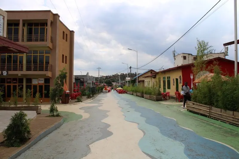 Dynamic street scene in Nyamirambo, Kigali with colorful architecture and vibrant patterns.